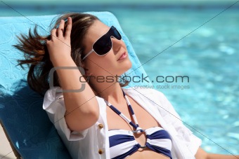 Girl sunbathing by the pool