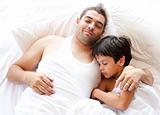 father and sone asleep on bed