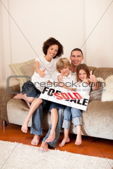 Family sitting on sofa in new house