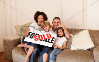 Family sitting on sofa in new house