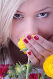 Blond woman hiding behind colorfoul flowers