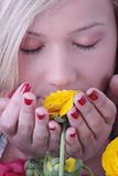 Blond woman hiding behind colorfoul flowers