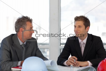Potrait of Two Engineers looing at Blueprints in office