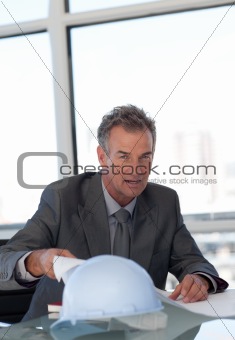 Mature Business man looking at Blueprints