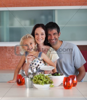 Young family smiling at camera indoors