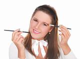 Beautiful girl applying makeup with two brushes