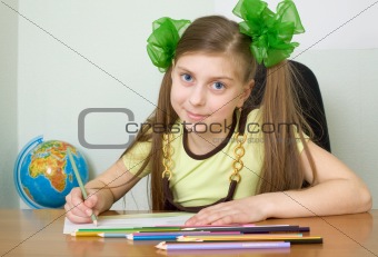 Girl sitting at a table with pencils