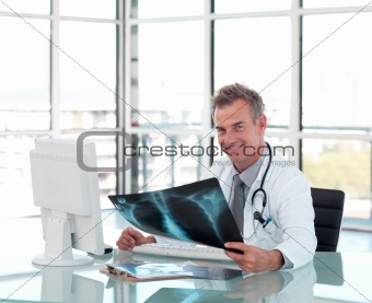 Middle aged doctor working at his Desk