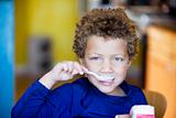 Boy with blue eyes eating yogurt