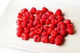 Red raspberries on white plate