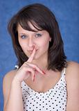 Mysterious girl with a finger near lips