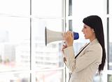 Business woman shouting in a megaphone