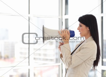 Business woman shouting in a megaphone