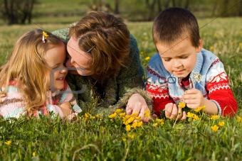 Woman and kids relaxing on the spring meadow