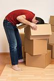 Man unpacking from cardboard boxes in a new home