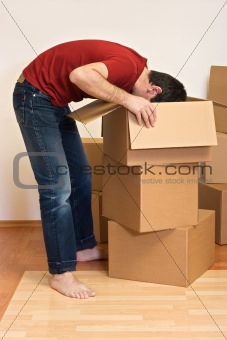 Man unpacking from cardboard boxes in a new home