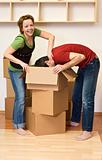 Couple having fun while unpacking in their new home