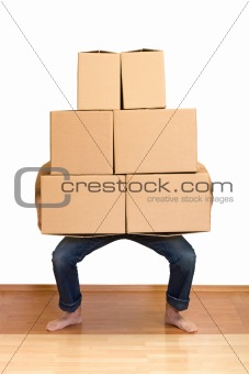 Man struggling while lifting lots of cardboard boxes