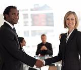 Business handshake in front of workgroup