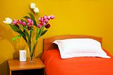 bed with an orange coverlet