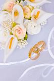 wedding rings and flowers over veil