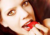 Sexy young woman eating a strawberry