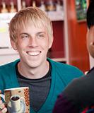 Man in coffee house with male friend