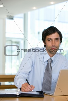 Young businessman working on laptop in urban setting