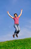 Young happy woman jumping high against blue sky