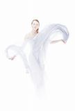 Young woman waving by light fabric over white high key