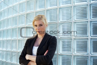 business woman leaning on glass bricks