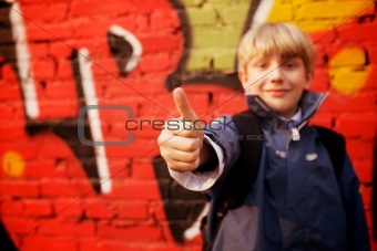 Kid standing in front of a graffiti wall