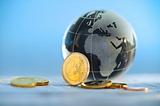 Globe showing Europe, Africa, and Middle East next to Euro coins