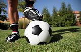man standing with foot on soccerball