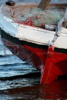 Red and White Sailing boat stranded at low tide in ocean Mozambi