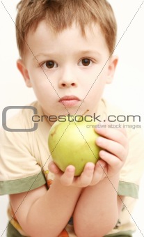 Sight of the boy with a green apple in a hand