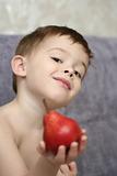 The boy, holds a red pear in a hand