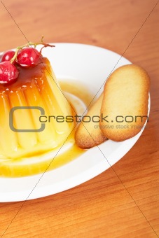 Cream caramel dessert with red currants and cookies