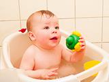 Cute baby boy enjoying a bath with copyspace