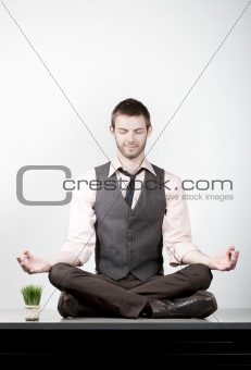 Handsome Young Businessman Meditating on Desk