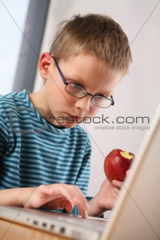 Computer kid. Eating apple
