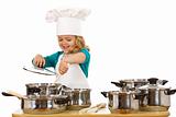 Happy chef girl stirring soup in a bowl
