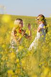 happy mother and daughter in traditional clothes in yellow flowe