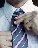 Business man adjusting his tie.