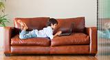 Kid playing with a laptop on the sofa