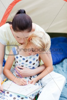 Mother and daughter wirting in tent