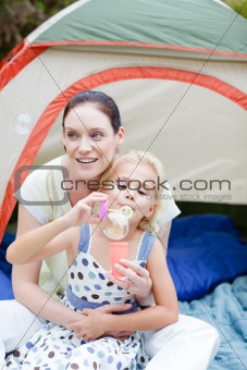 Mother and daughter having fun with bubbles