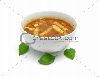 Noodle soup with tomatoes and herbs on white
