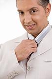 close view of smiling businessman holding tie
