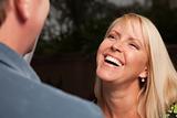 Attractive Blonde Woman Socializing with Man at an Evening Gathering.